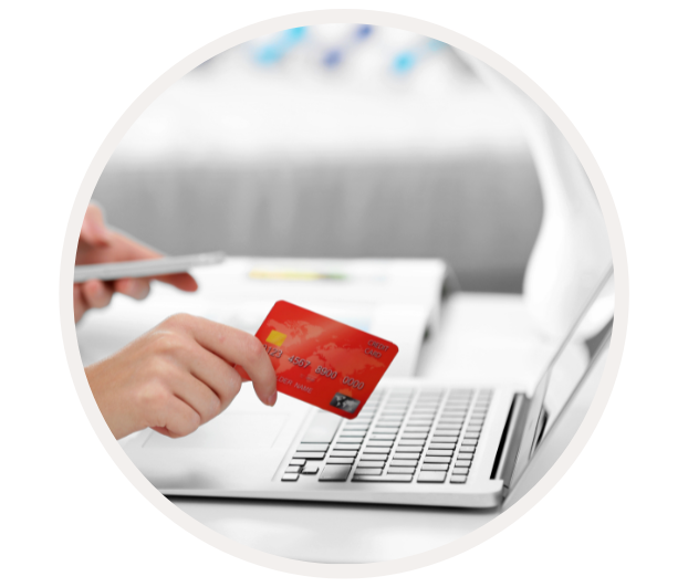 Person hält Kreditkarte und nutzt Laptop für Online-Shopping